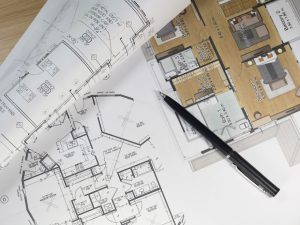 Top view of architectural blueprints and blueprint rolls and a drawing instruments on the worktable,Part of architectural project,renovation planning concept